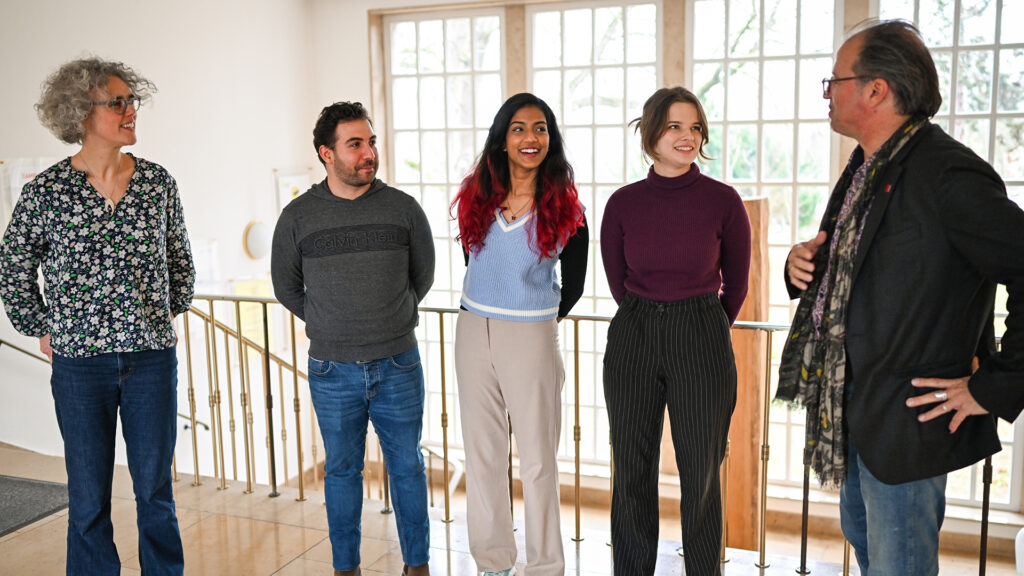 Drei Studierende des Masterstudiengangs - Giuseppe Di Paola (2.v.l.), Sharon Ann Titus (m.) und Habriela Danko (2.v.r) - im Gespräch mit JGU-Vizepräsident Prof. Dr. Stephan Jolie (r.) und Dr. Jessica Quinlan (l.).