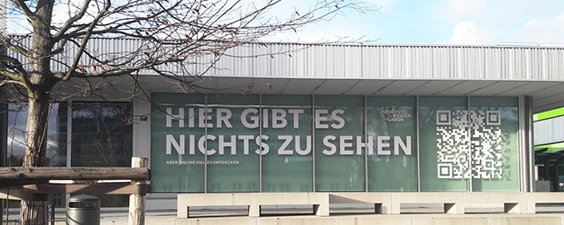 Die Ausstellung 'Hier gibt es nichts zu sehen' findet rein digital statt. Die Fassade der Schule des Sehens auf dem Gutenberg-Campus wirbt für den Online-Ausstellungsbesuch. (Foto: Philipp Neuweiler)