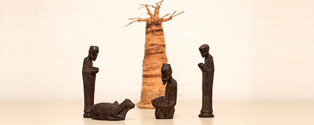 Diese Weihnachtskrippe aus Nigeria zeigt Figuren aus Ebenholz vor der Nachbildung eines Affenbrotbaums aus Bananenblättern. (Foto: Stefan F. Sämmer)