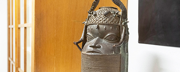 Der überlebensgroße Bronzekopf schmückte im 19. Jahrhundert einen Altar im Königspalast von Benin – heute begrüßt er die Besucher der Ethnografischen Studiensammlung der JGU. (Foto: Stefan F. Sämmer)
